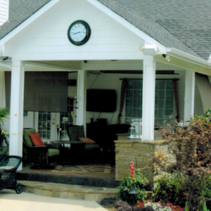 A home with a large, covered backyard porch full of patio furniture.