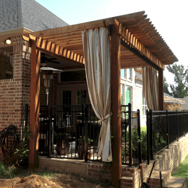 A large wooden shade structure overhanging a back porch.