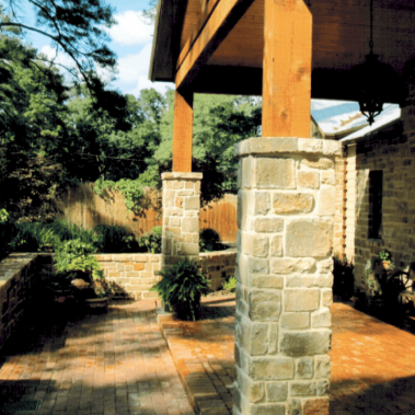 A freshly redesigned back yard porch featuring intricate stone and brickwork.